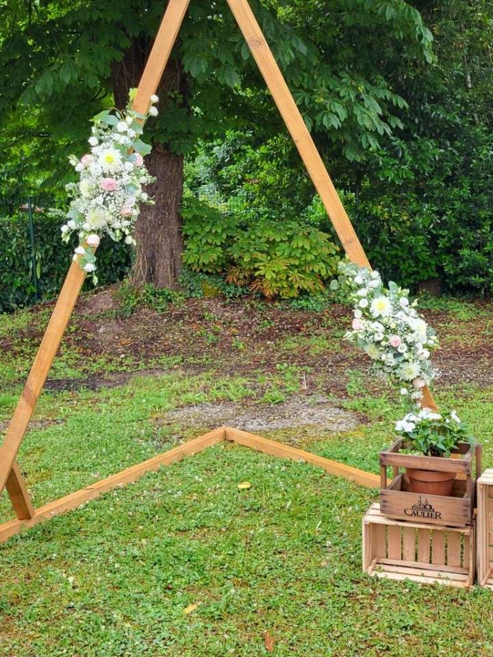 Une arche triangulaire en bois décorée de fleurs Cognac